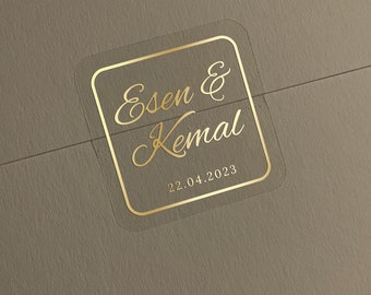 Pode incluir: Um adesivo transparente com uma borda dourada e letras douradas. O adesivo diz "Esen & Kemal" e "22.04.2023".