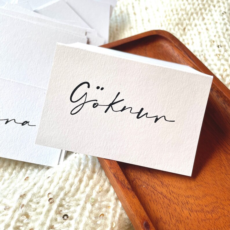 May include: A white card with the text "G&ouml;knum" written in black cursive script.