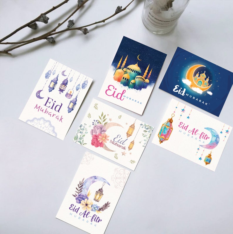 May include: Five different greeting cards with watercolor designs for Eid Mubarak and Eid Al-Fitr. The cards feature crescent moons, lanterns, stars, and floral designs.