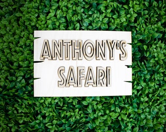 May include: A white wooden sign with the text "Anthony's Safari" in black outlined letters.