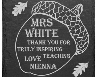 May include: Black slate coaster with a white acorn design. The text "MRS WHITE THANK YOU FOR TRULY INSPIRING LOVE TEACHING NIENNA" is engraved on the coaster.
