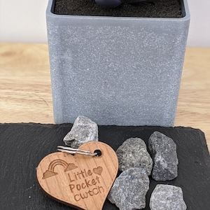May include: Wooden heart-shaped keyring with a rainbow and the text "Little Pocket Clutch".