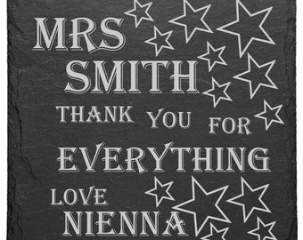 May include: Black slate plaque with white text that reads "Mrs. Smith Thank You For Everything Love Nienna" with white stars around the text.