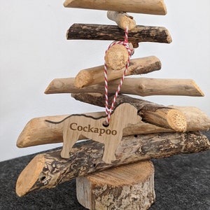 May include: A wooden driftwood Christmas tree with a wooden dog ornament that says "Cockapoo".
