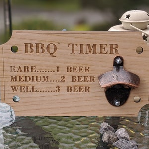 Puede incluir: Señal de madera con un abridor de botellas. La señal dice "BBQ TIMER" y enumera "RARE...1 CERVEZA", "MEDIUM...2 CERVEZAS", y "WELL...3 CERVEZAS".