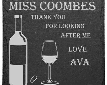May include: Black slate coaster with a white wine bottle, wine glass, and cork. The text reads "Miss Coombes Thank You For Looking After Me Love Ava".