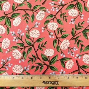May include: A pink fabric with a white floral pattern. The flowers are stylized peonies with green leaves and stems. A wooden ruler with the text "Westcott Since 1872" is at the bottom of the image.