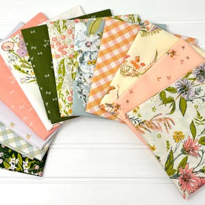 May include: A collection of fabric squares in various floral and patterned designs. The fabrics feature colors like green, pink, orange, and white. Some have gingham, floral, and bow patterns. The squares are arranged in a fan shape.