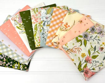 May include: A collection of fabric squares in various floral and patterned designs. The fabrics feature colors like green, pink, orange, and white. Some have gingham, floral, and bow patterns. The squares are arranged in a fan shape.