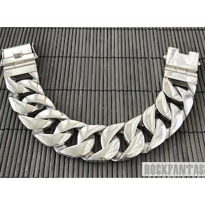Op de afbeelding: Een zilveren kettingarmband met een groot, chunky link-ontwerp. De armband is gemaakt van gepolijst metaal en heeft een veilige sluiting.
