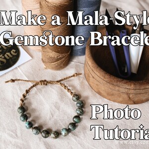 May include: A photo tutorial on how to make a mala-style gemstone bracelet. The image shows a bracelet made with turquoise beads and brown cord, along with supplies like spools of thread and a wooden bowl.