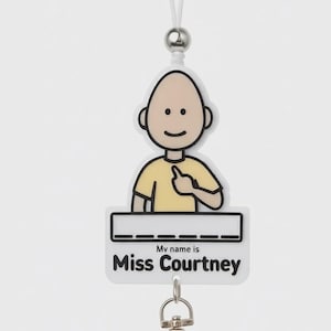 May include: A white lanyard featuring a cartoon character with a pale skin tone and a yellow shirt. Below the character is a white rectangular name tag with the text My name is Miss Courtney in black font and a blank space for additional writing.