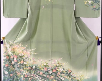 May include: A green silk kimono with a floral pattern of pink, white, and yellow flowers. The flowers are arranged in a flowing design on the fabric.