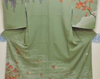 May include: A green kimono with a floral pattern. The pattern includes wisteria flowers, maple leaves, and clouds. The kimono is decorated with a wave pattern and a border of red and gold flowers.