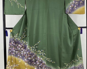 May include: A green silk kimono with a floral pattern in shades of purple, pink, and gold. The kimono has a traditional Japanese design and is perfect for special occasions.