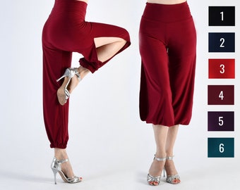 May include: A pair of burgundy wide-leg pants with a side slit and a gathered cuff at the ankle. The pants are made of a soft, stretchy fabric and have a high waist.