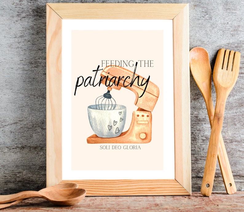 May include: A framed print with a watercolor illustration of a stand mixer with a bowl and whisk. The text "Feeding the patriarchy" is written in cursive above the mixer. The text "Soli Deo Gloria" is written below the mixer.