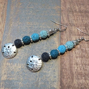May include: A pair of long dangle earrings with black and blue lava rock beads and silver sand dollar charms.
