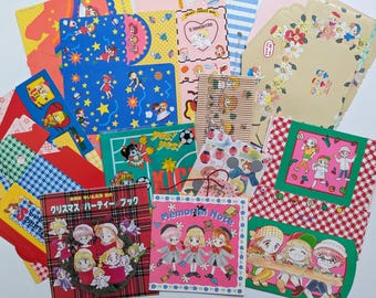 May include: A collection of colorful stationery items, including notebooks, cards, and envelopes. The designs feature cartoon characters, stars, and floral patterns. Some items have Japanese text.