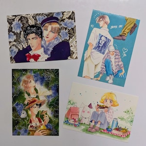 May include: Four colorful postcards featuring anime-style illustrations. One shows two figures with a floral background, another depicts figures with the text "BOYS BE", and the others show picnic and garden scenes.