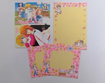 May include: A collection of stationery featuring manga-style illustrations. Includes a large yellow notepad with floral accents and several pink notecards. The artwork depicts anime characters and floral designs. The text on the cover reads "MIYAGI RIKO".