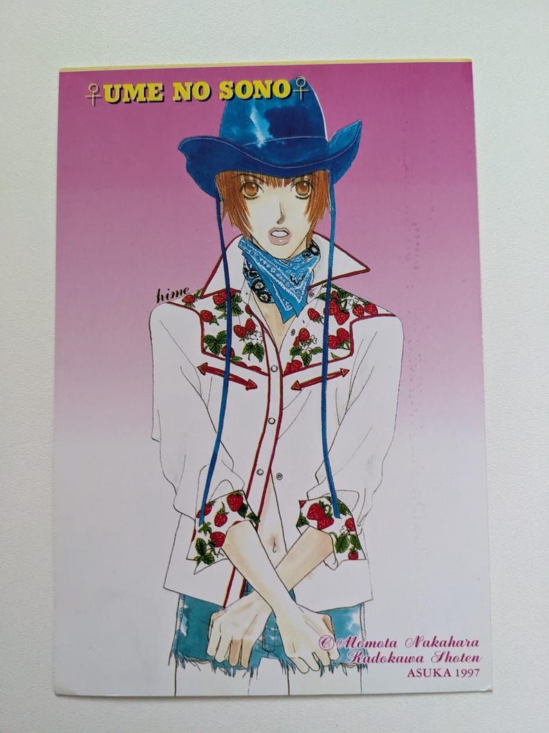 Pu&ograve; includere: Illustrazione di una persona con cappello da cowboy blu, camicia bianca con dettagli di fragole e bandana blu. Il testo "UME NO SONO" &egrave; in alto. L'immagine &egrave; firmata da Momota Nakahara, Kadokawa Shoten, ASUKA 1997.