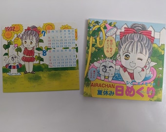 Könnte beinhalten: Zwei japanische Vintage-Kalender im Anime-Stil. Einer zeigt ein Mädchen, das Sonnenblumen gießt, mit einem Kalender von 1992. Der andere zeigt ein Mädchen in einem Pool mit einem Hund, mit japanischem Text. Beide haben einen gelben Hintergrund.