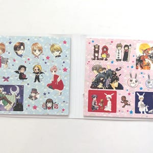 Op de afbeelding: Een set van twee stickervellen met diverse illustraties van anime-personages. De linkerpagina heeft een lichtblauwe achtergrond met sterren en vlinders, terwijl de rechterpagina een lichtroze achtergrond heeft met sterren en diverse scènes.
