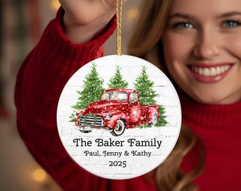 May include: A round Christmas ornament featuring a red vintage truck with a Christmas tree design. The ornament has the text "The Baker Family" and the names Paul, Jenny & Kathy, and the year 2025.