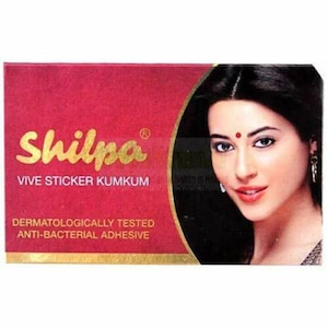 May include: A red and gold package with the text "Shilpa® Vive Sticker Kumkum" and "Dermatologically Tested Anti-Bacterial Adhesive". The package features a woman with dark hair and a red dot on her forehead.