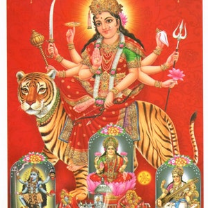 May include: A colorful illustration of a Hindu goddess riding a tiger. The goddess has multiple arms and is adorned with jewelry. The image includes the text "माँ के दर्शन" in Hindi.