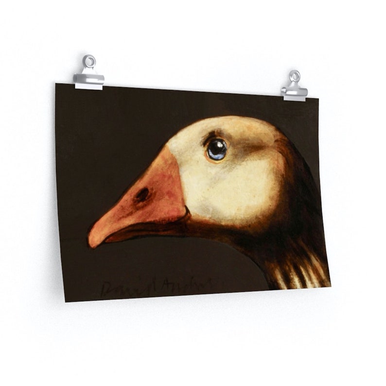 May include: A print of a goose head in profile, featuring a cream-colored head and a reddish-orange beak. The goose has a blue eye and is set against a dark brown background. The artist's signature is visible at the bottom.