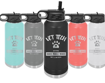 Op de afbeelding: Vijf roestvrijstalen waterflessen met een zwarte dop en een rietje. Elke fles heeft een andere kleur: turquoise, grijs, zwart, koraal en wit. De flessen hebben een pootprint met een hart en de tekst "Vet Tech Because Badass Miracle Worker Isn't A Job Title."