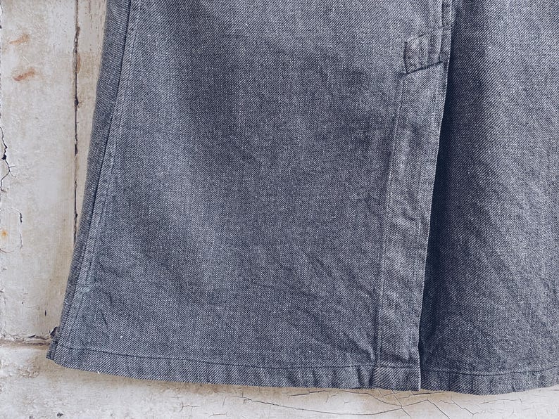 May include: A dark gray denim skirt with a seam down the front.