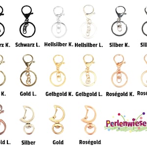 Könnte beinhalten: Sortiment an Schlüsselringen in verschiedenen Ausführungen, darunter Schwarz, Silber, Gold, Roségold und Gelbgold. Die Schlüsselringe sind in großen und kleinen Größen dargestellt.