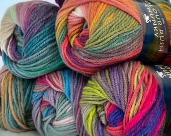 May include: Four skeins of colorful yarn in shades of green, blue, purple, pink, orange, and yellow. The yarn is chunky and has a variegated color pattern. The yarn is labeled "Colour Rush Chunky" and "100% Acrylic".