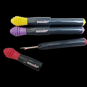 Könnte beinhalten: Vier Nahttrenner mit schwarzen Griffen und farbigen Enden. Zwei haben gelbe und lila Enden, und einer hat ein rotes Ende. Der vierte Nahttrenner ist zerlegt, mit einem roten Ende und freiliegender Klinge. Der Text "seam-fix" ist auf den Griffen aufgedruckt.