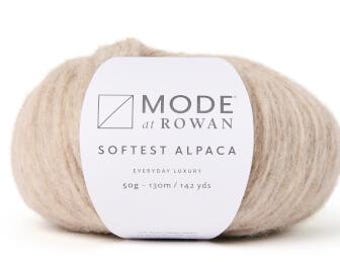 May include: A skein of beige yarn labeled "MODE at ROWAN Softest Alpaca Everyday Luxury 50g - 130m / 142 yds"