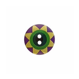 May include: A round, two-hole button featuring a central dark green circle surrounded by a yellow star-shaped pattern on a purple background. The design is symmetrical, with the yellow points extending toward the outer edge of the circular button.