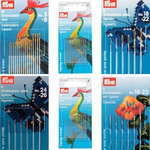 Op de afbeelding: Een set van zes borduurnaalden met een blauwe en groene vogel illustratie op de verpakking. De naalden zijn gemarkeerd met "No. 3 - 9" en "Embroidery crewel".