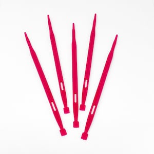 May include: Five bright pink plastic yarn needles are arranged on a white background. Each needle has a long, slender body with a pointed tip and a small rectangular base. A small rectangular hole is cut into the body of each needle.