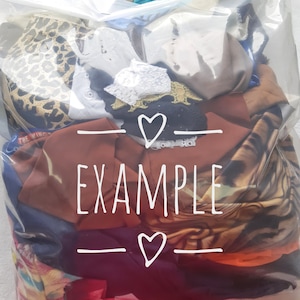 May include: A clear plastic bag filled with a variety of colourful fabrics and clothing items. The bag has a white label with the word "EXAMPLE" and two hearts.