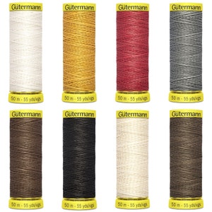 May include: Eight spools of Gütermann thread in various colours, including white, yellow, red, grey, brown, black, beige, and tan. Each spool is labelled with the brand name "Gütermann" and the length of the thread in metres and yards.