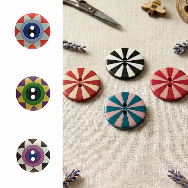 May include: A collection of round, two-hole buttons featuring various geometric patterns. The designs include starbursts, radial stripes, and eye-like motifs in colors such as red, blue, green, purple, black, white, and pink, arranged in a set.