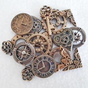 May include: A collection of vintage-style metal charms featuring clock faces, gears, and a compass. The charms are in shades of gold and bronze and have a steampunk aesthetic.