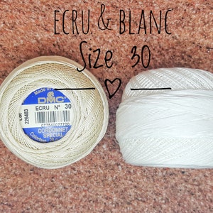 May include: Two spools of DMC Cordonnet Special embroidery floss, one in ecru and one in white. Both spools are size 30.