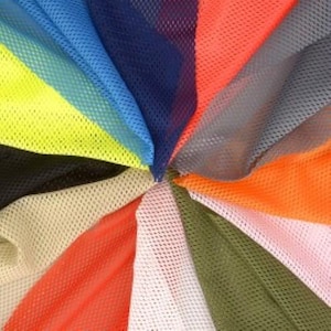 May include: A variety of colours of mesh fabric, arranged in a circular pattern. The colours include yellow, blue, red, orange, grey, black, beige, white, and green.