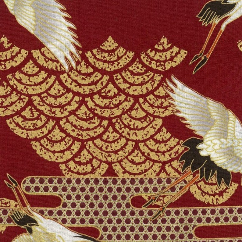 Puede incluir: Tela roja con un patr&oacute;n dorado y blanco de grullas estilizadas y un patr&oacute;n repetitivo de escamas superpuestas. La tela tiene una superficie texturizada.