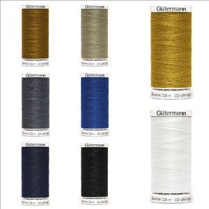 May include: Eight spools of Gütermann Denim thread in various colours, including gold, grey, blue, dark blue, black, and white. Each spool is labelled with the brand name and the length of the thread in yards and metres.