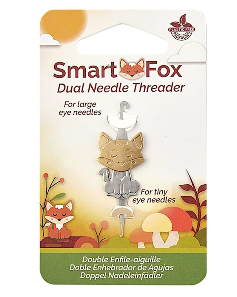 May include: A Smart Fox dual needle threader for large and tiny eye needles. The packaging features a fox illustration and text in English, French, Spanish, and German. The packaging is plastic-free.